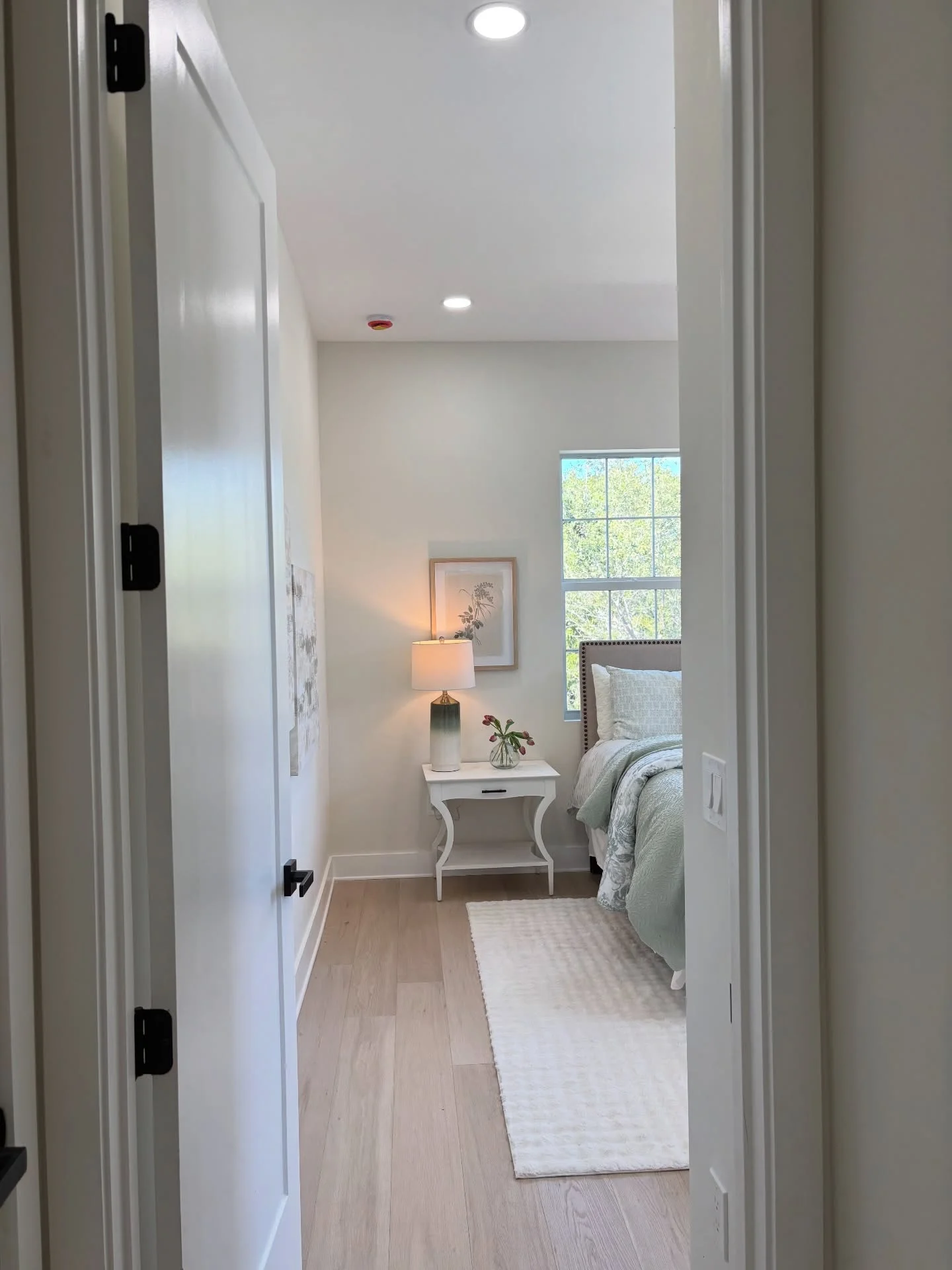 Inviting bedroom styled with soft layered linens, a bedside lamp and warm neutral colors