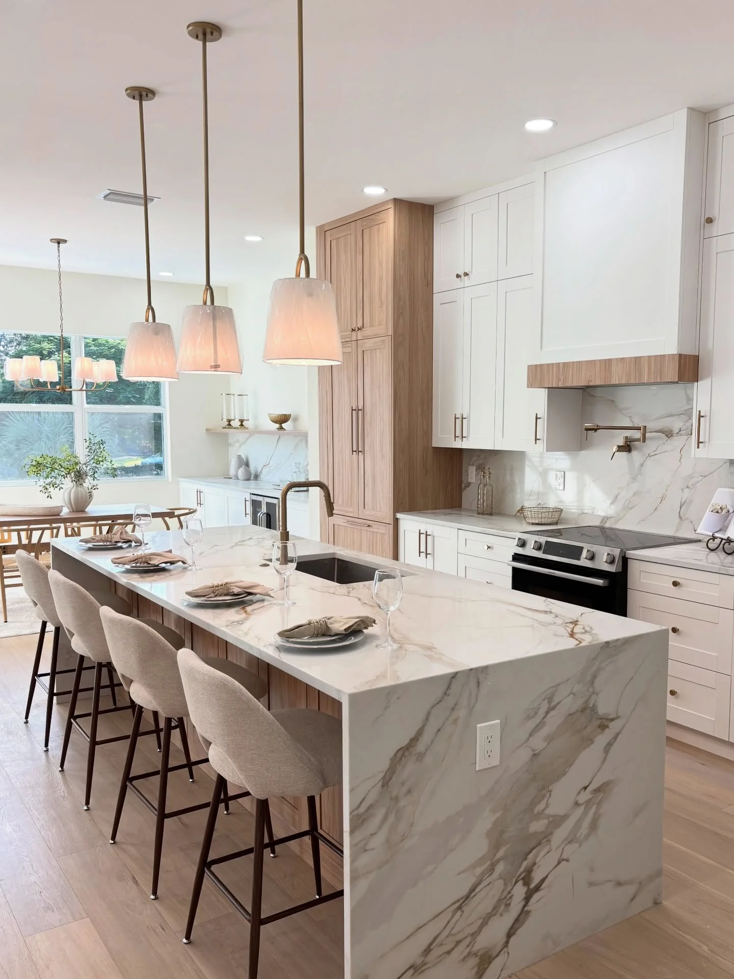 Marble kitchen island with warm pendant lights and carefully styled tableware