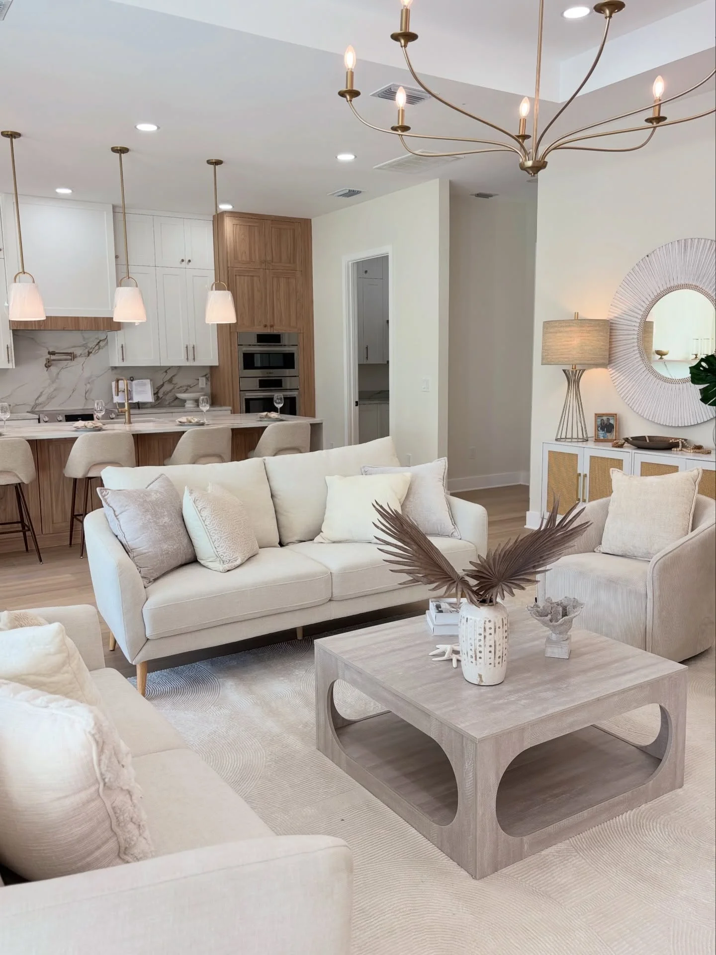 Open living room staged with a neutral sofa, sculptural table and warm wood furnishings